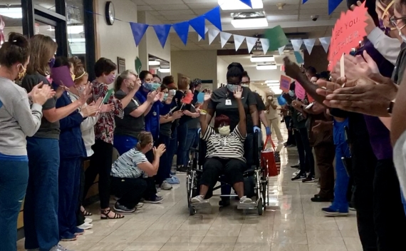 woman in wheelchair with people cheering